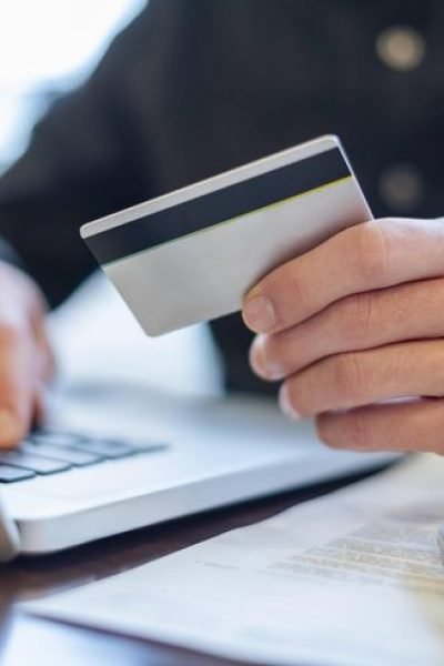 Hand holding a credit card near a laptop for online payment model released, Symbolfoto, DIGF23685